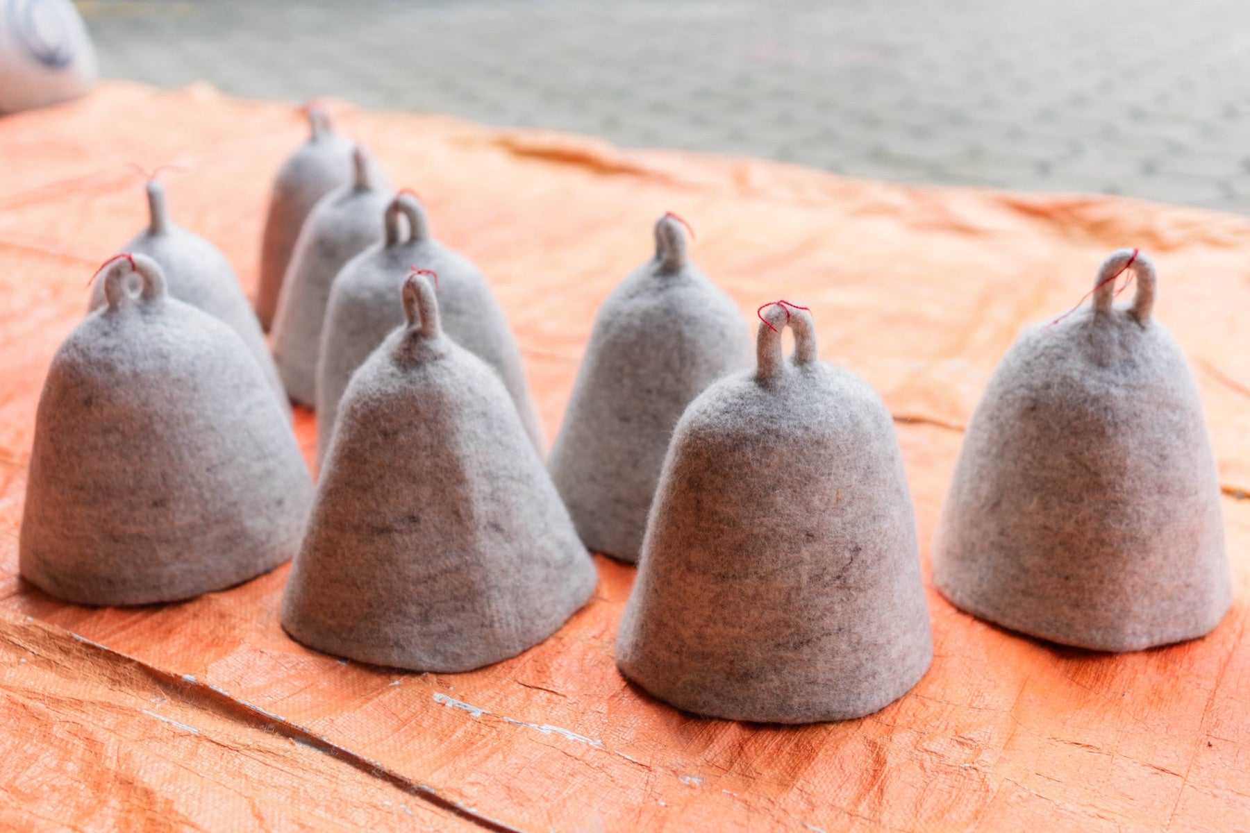 A batch of nine hand-felted wool sauna hats, no two exactly alike