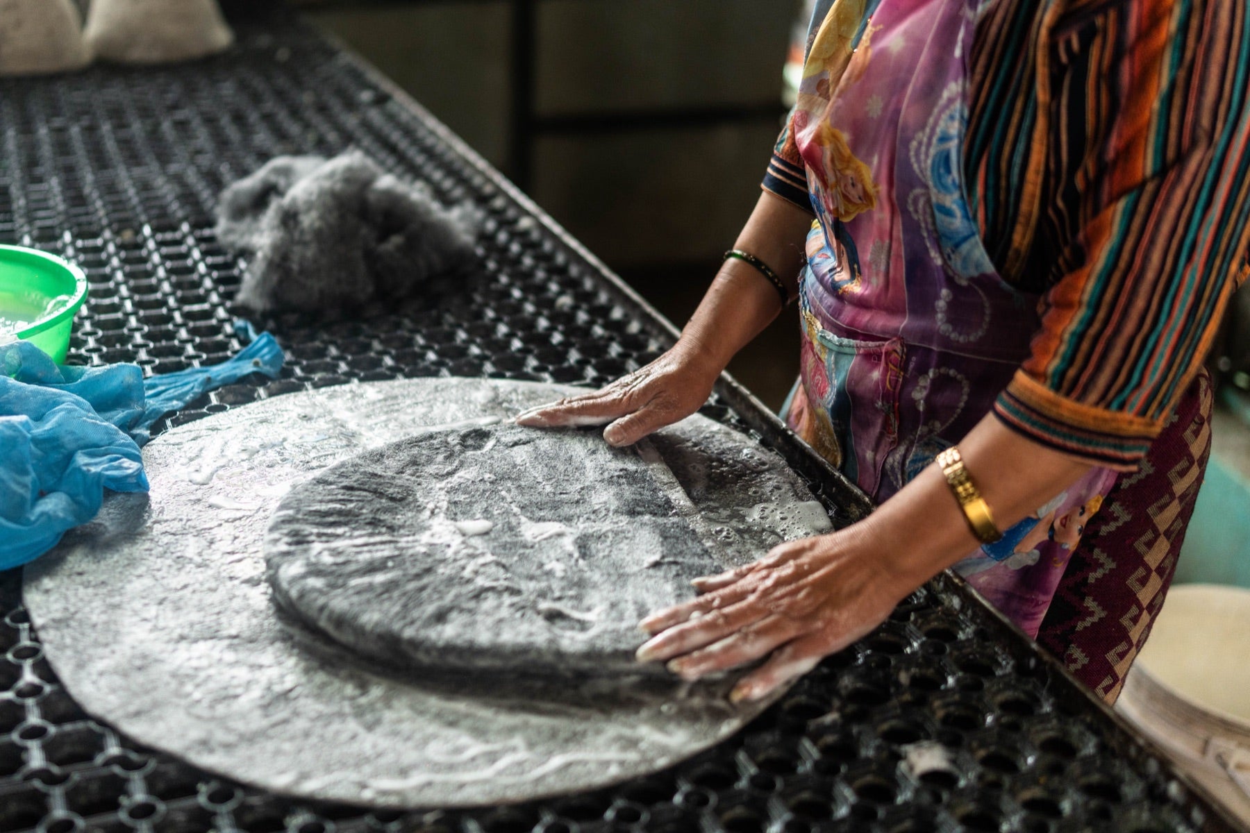 Hands pressing a soaked disc of wool during wet felting of a Cult of Sauna hat