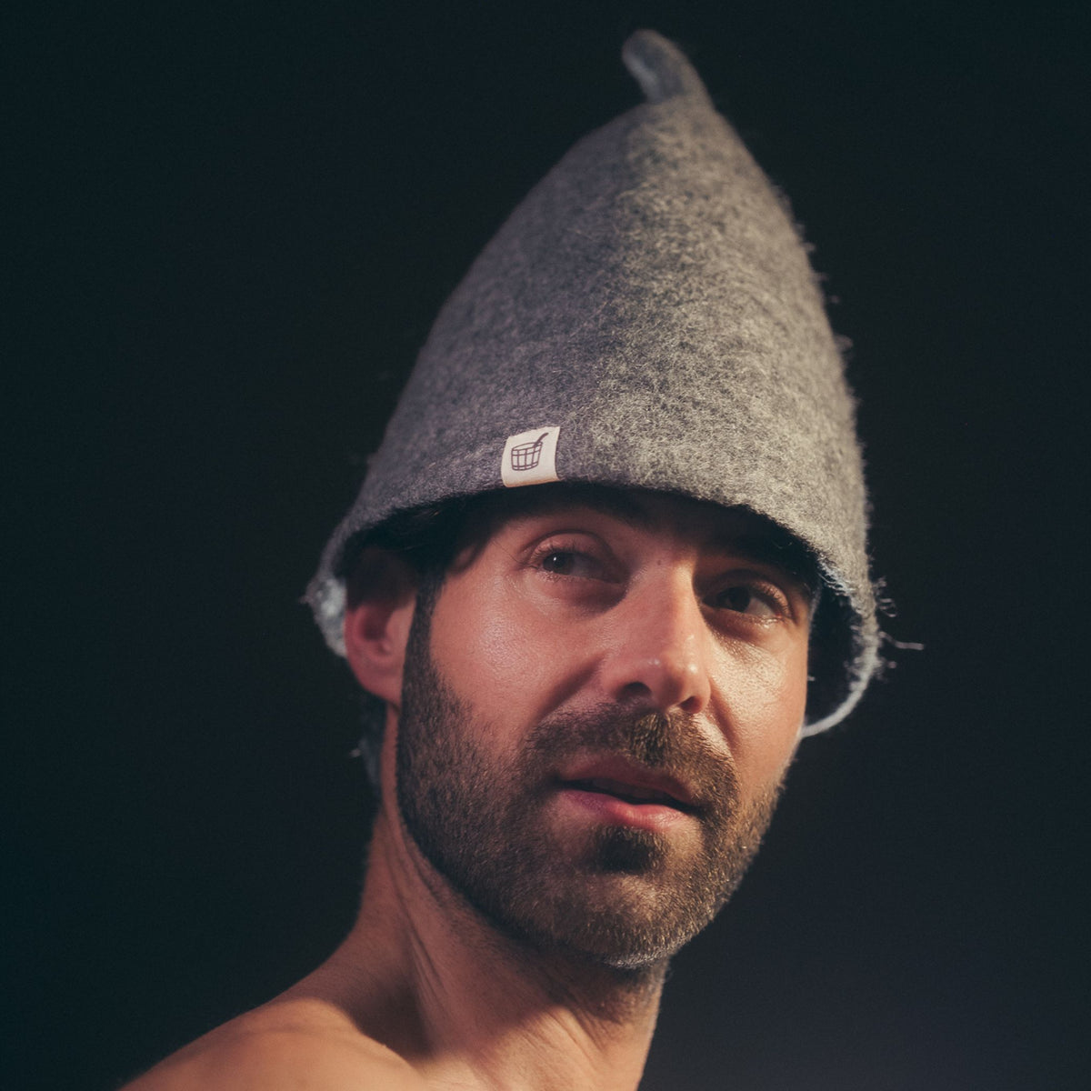 Man wearing the Volcanic Grey wool felt sauna hat, brim covering his ears and forehead