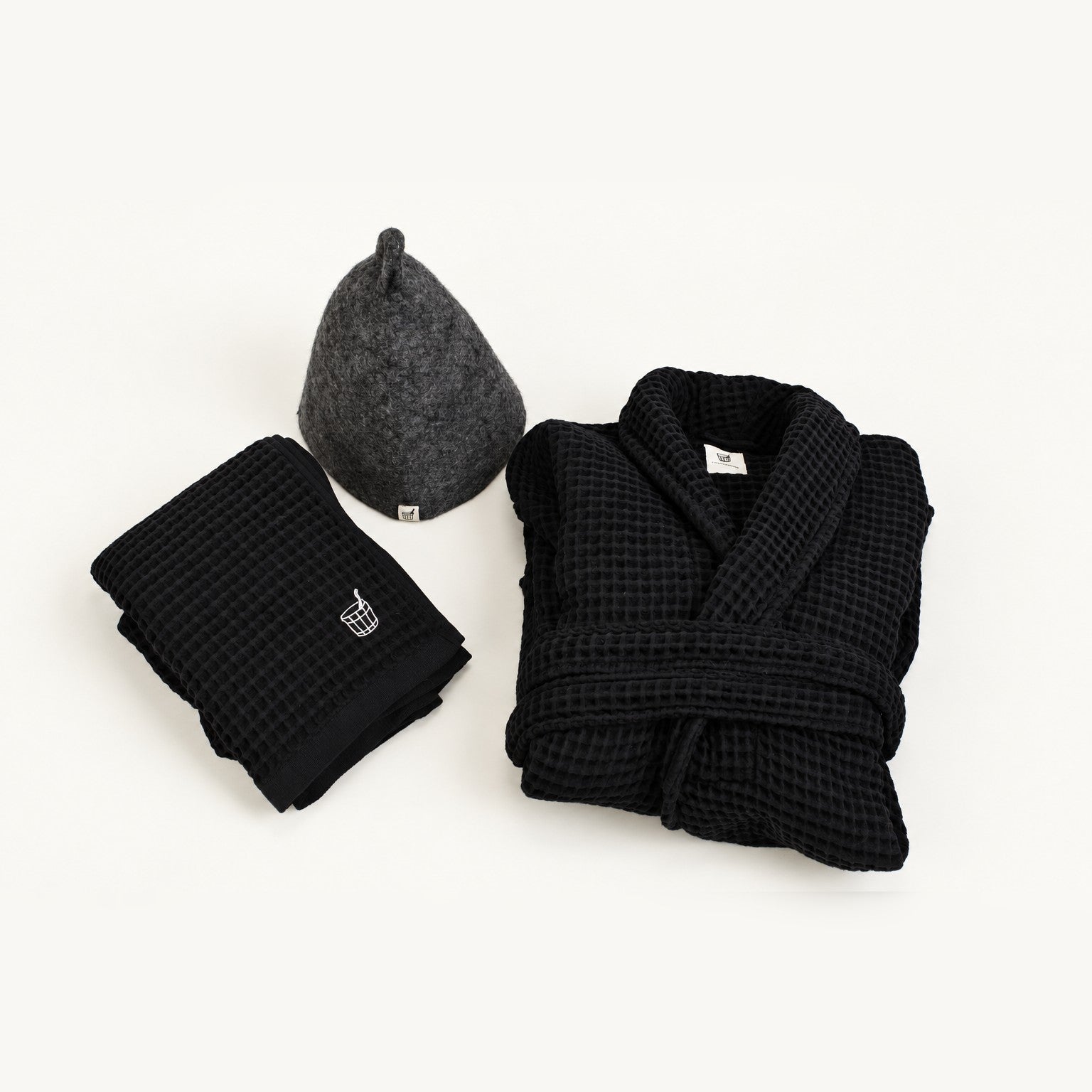 The Ritual Set sauna gift set in Aurora: wool sauna hat, waffle cotton towel and robe laid out